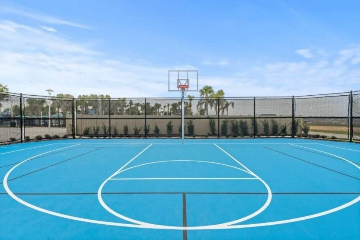 En utomhusbasketplan med blått underlag, vita linjer som markerar planen och en basketkorg.