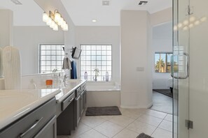 A modern bathroom with a large mirror, a bathtub, and a window with a view of palm trees. - Walk To All- Townhouse in Old Town Scottsdale Right Off Canal (Scottsdale)