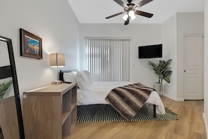 A modern bedroom with a bed, a desk, a ceiling fan, a TV, and a plant. - Walk To All- Townhouse in Old Town Scottsdale Right Off Canal (Scottsdale)