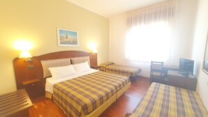 A hotel room with a bed, two bedside tables, a desk with a chair, a television, and a window with curtains. - Agriturismo Gli Ulivi (Predappio)