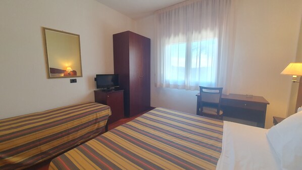 A hotel room with a bed, a sofa, a TV, a desk, and a chair. - Agriturismo Gli Ulivi (Predappio)