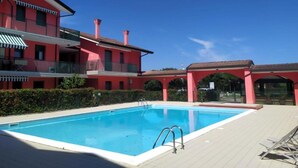 Una piscina con un edificio rosso sullo sfondo.