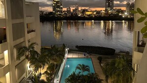 Zona de piscina con vista a un horizonte urbano al atardecer.