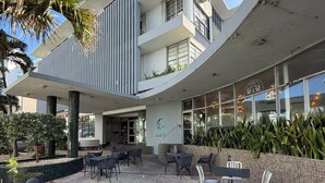 Un edificio moderno con techo plano, zona de estar al aire libre y un letrero que dice 'La Hada'.
