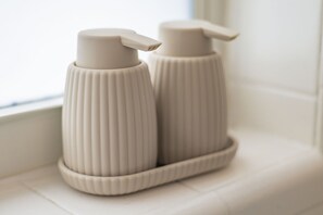 Two white, ribbed, pump-style bottles on a white surface. - Pompano 3225 20A (Pompano Beach)