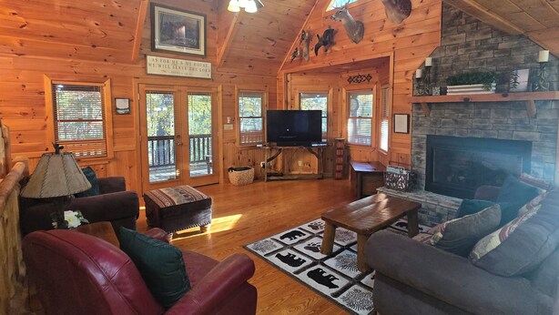 A log cabin interior with a fireplace, television, and wooden furniture. - Blue Ridge, North GA Cabin: Sleeps 10 & 2 pets • hot tub • Fast wifi • fire pit (Blue Ridge)