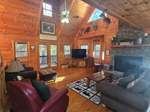 A log cabin interior with a fireplace, television, and wooden furniture. - Blue Ridge, North GA Cabin: Sleeps 8, hot tub, Fast Starlink wifi • fire pit (Blue Ridge)