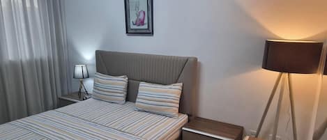 Tabla de planchar con plancha, internet y ropa de cama