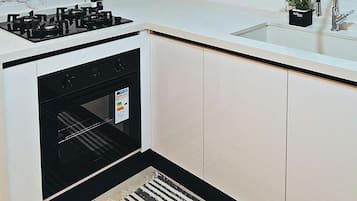Une cuisine moderne équipée d’une cuisinière, d’un four et d’un évier avec un robinet.