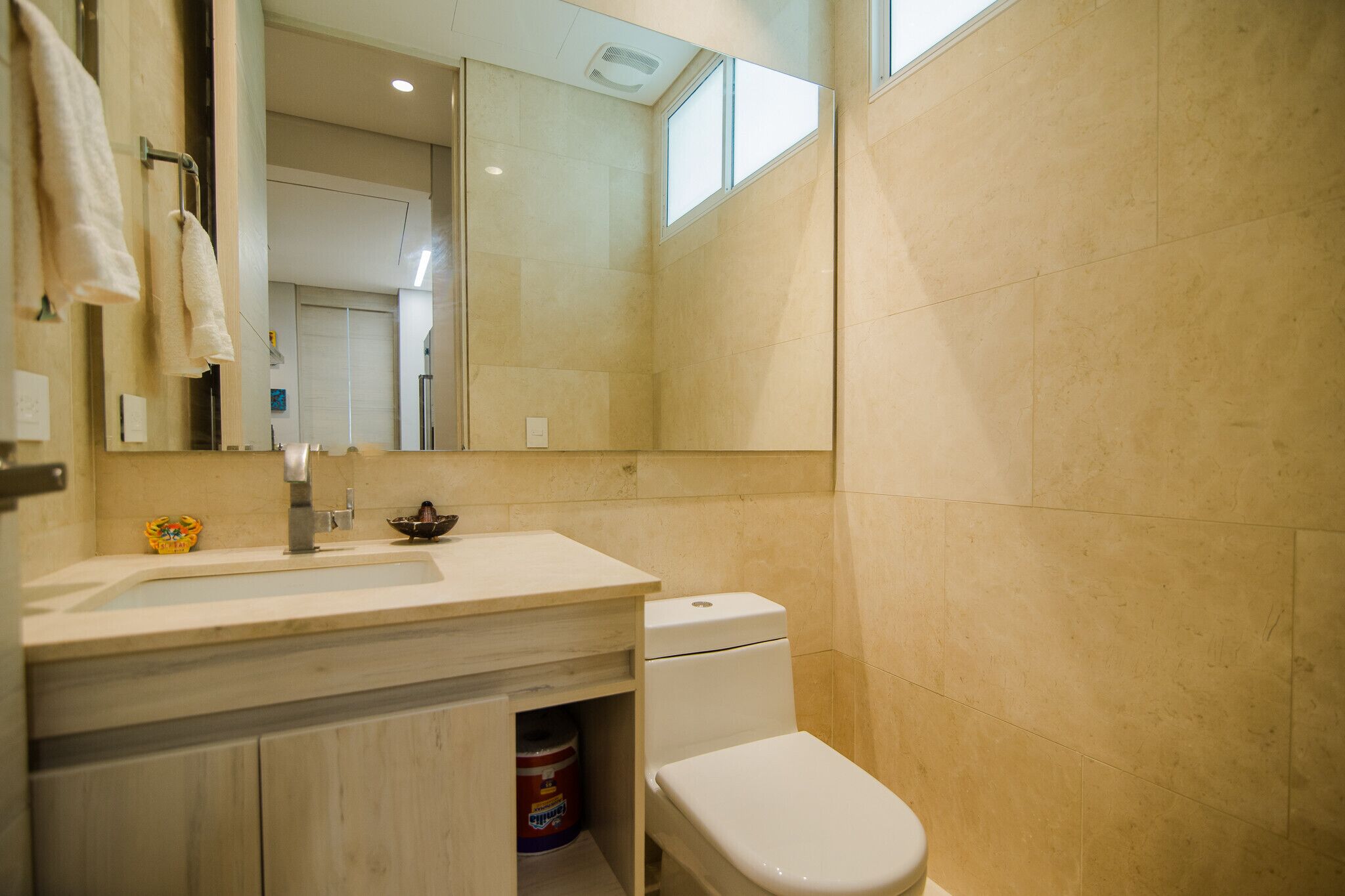 A bathroom with a sink, toilet, and mirror.