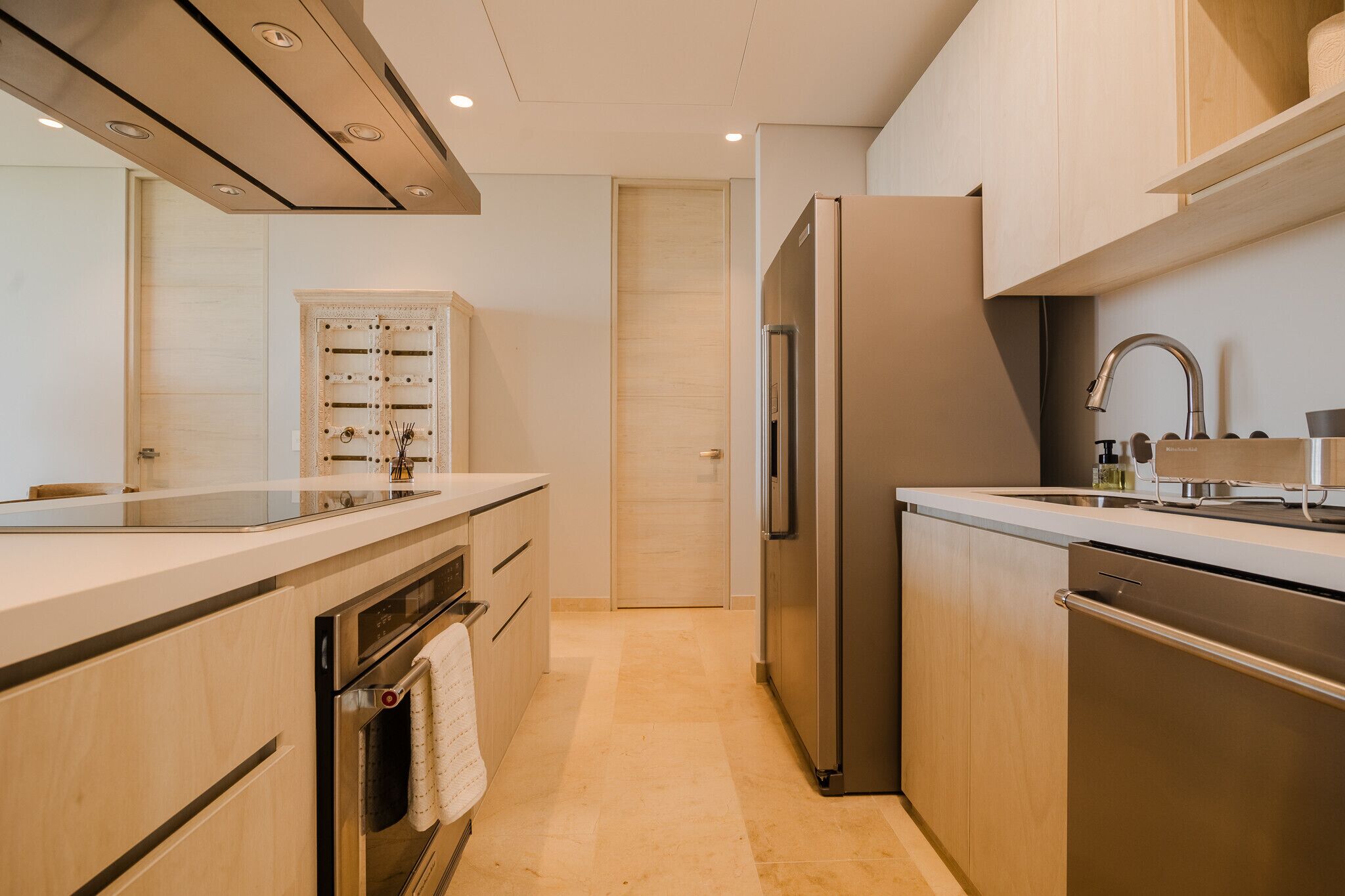 A modern kitchen with stainless steel appliances, wooden cabinets, and a built-in oven.