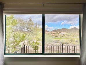 A room with a large window offering a view of a desert landscape with sparse vegetation and distant hills. - Modern Resort Home @ Starr Pass Golf Resort (Tucson)