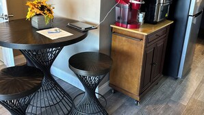 A modern kitchen with a round dining table, black metal chairs, a coffee maker, and a refrigerator. - Manatee Riverfront Home , Cozy 2-bedroom house in Ellenton “Duplex”, left side.  (Ellenton)