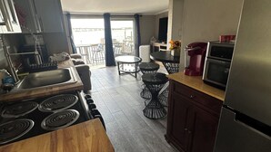 A modern kitchen with a gas stove, stainless steel appliances, and a dining area with a table and chairs. - Manatee Riverfront Home , Cozy 2-bedroom house in Ellenton “Duplex”, left side.  (Ellenton)
