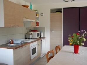 Una cucina moderna con mobili in legno, un forno a microonde, un tostapane e un lavandino.