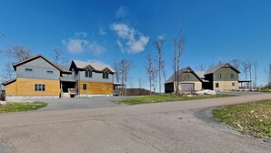 A residential area with a two-story house, a garage, and a barn.