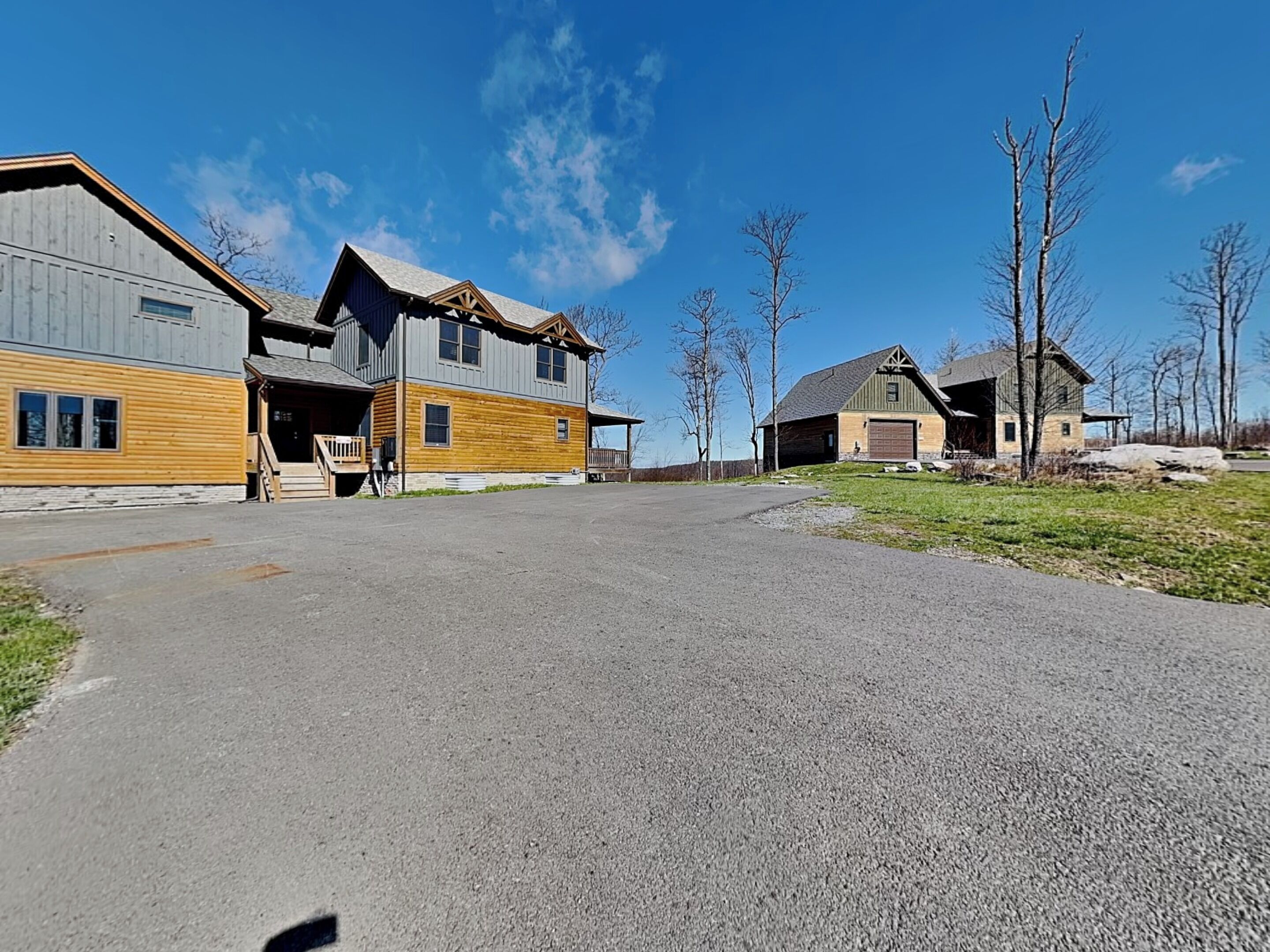 A residential area with a large house featuring a porch and a garage.