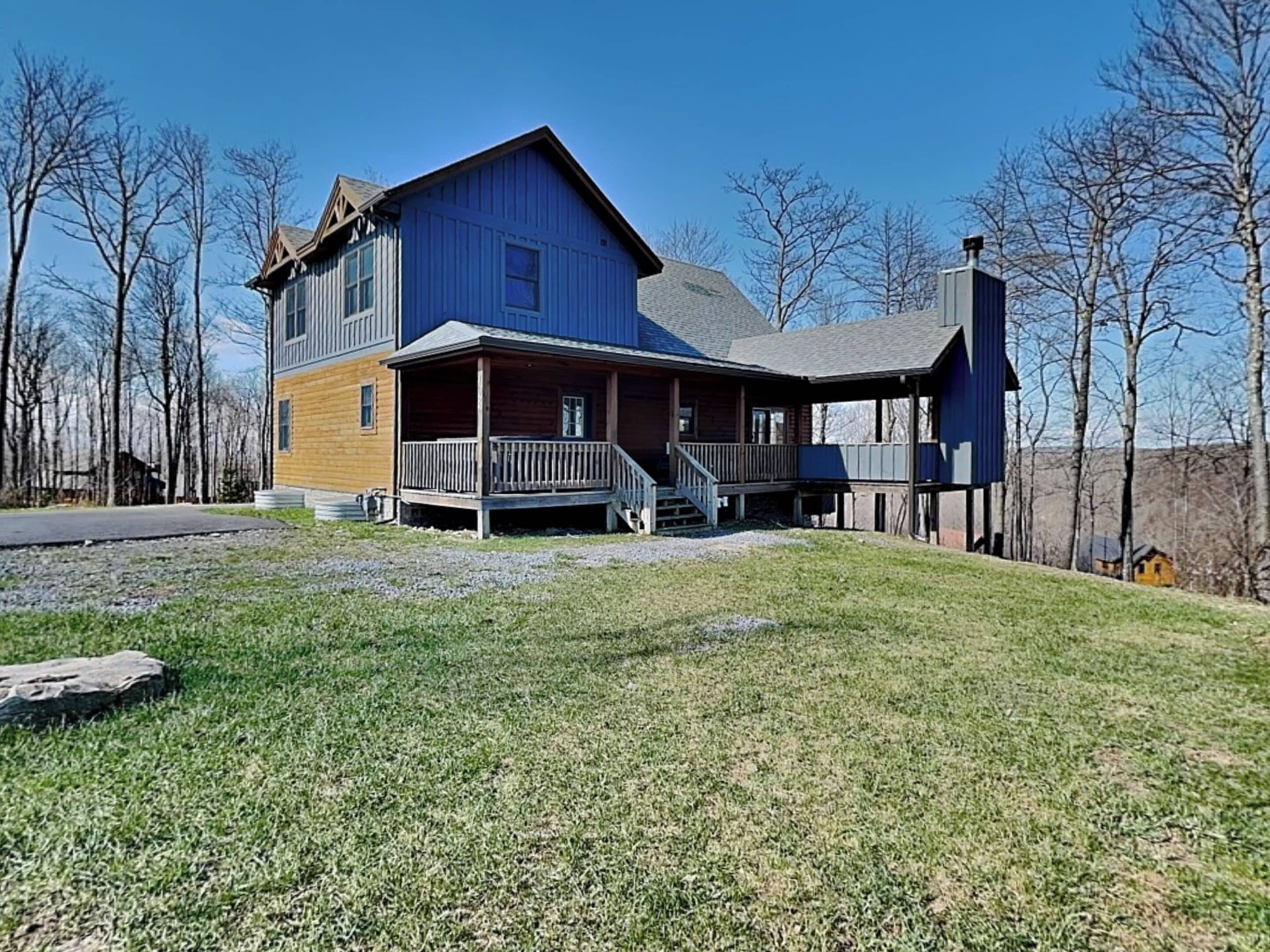 A two-story house with a porch, a chimney, and a grassy yard.