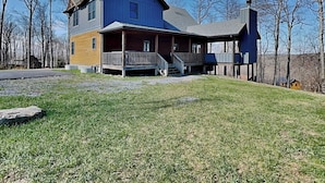 A two-story house with a porch, a chimney, and a grassy yard.