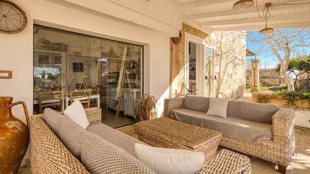 A cozy outdoor seating area with wicker furniture, a large window, and a view of the surrounding landscape. - Villa 'Camera 2' with Sea View, Private Pool and Wi-Fi (Lido Marini)