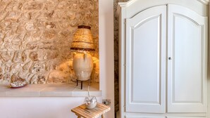 A stone wall, a lamp, a cabinet, and a small table with a bowl. - Villa 'Camera 2' with Sea View, Private Pool and Wi-Fi (Lido Marini)