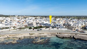 Un pueblo costero con edificios blancos, agua azul cristalina y un marcador amarillo.