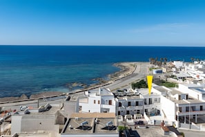 A coastal town with white buildings, a beach, and a clear blue sky. - Room 'Vista Mare Con Balcone 1' with Air Conditioning (Torre San Giovanni)