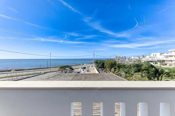 Un balcon avec vue sur la mer et les bâtiments.