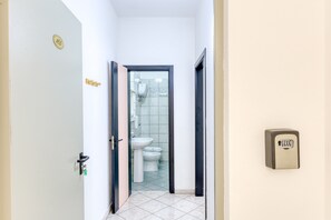 A narrow hallway leading to a bathroom with a toilet, bidet, and a hand dryer mounted on the wall. - Inn 'Doppia 2' with Sea View, Wi-Fi and Air Conditioning (Torre San Giovanni Ugento)