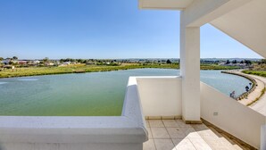 A balcony with a view of a river and distant buildings. - Inn 'Doppia 4' with Wi-Fi and Air Conditioning (Torre San Giovanni Ugento)