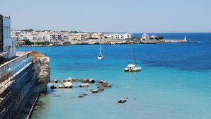 Une ville côtière avec des bâtiments, une jetée et des bateaux sur l’eau.