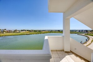 Ein Balkon mit Blick auf einen Fluss und entfernte Gebäude.
