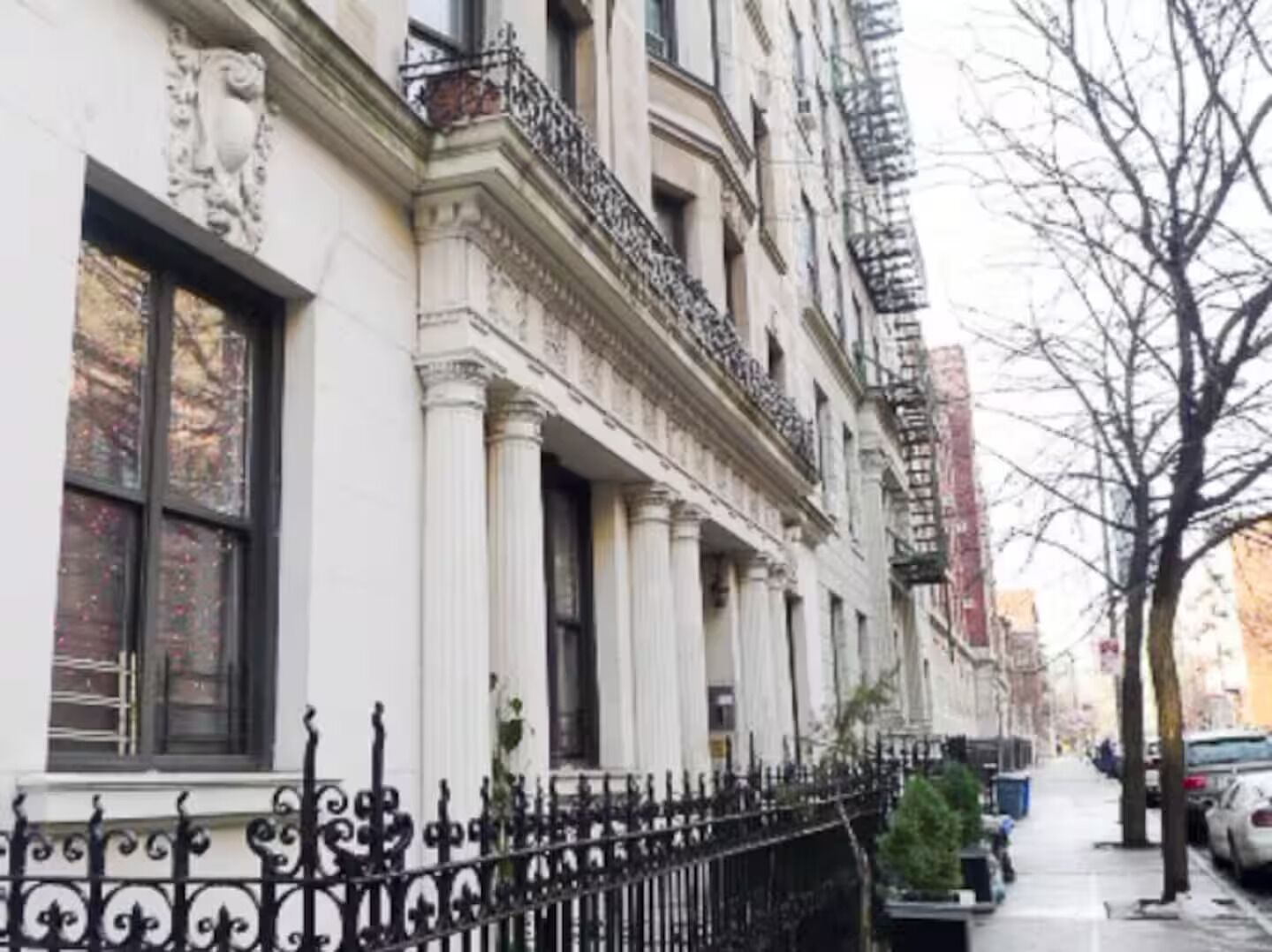 A row of white buildings with black iron railings and columns.