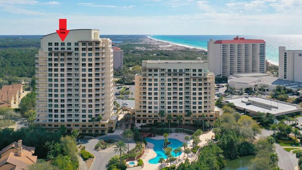 A high-rise hotel with a pool and a view of the ocean.
