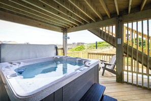 A hot tub on a wooden deck with a view of a staircase and greenery. - Nags Head Oceanfront w/ Pool, Sauna, Hot Tub! (Nags Head)