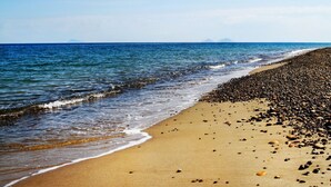 A beach with a pebbly shore and calm sea. - Villa Alice is an independent newly built villa, designed in the traditional “dammuso” style with its characteristic dome and overlooking the sea. It is a retreat immersed in nature, perfect for those seeking peace, privacy and an authentic stay. The (Marina di Caronia)