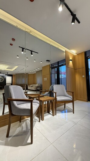A modern interior with a dining area, seating, and a large window. - Riva suites (Irbid)