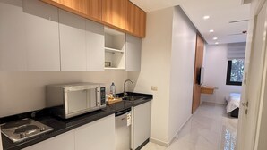 Μια μοντέρνα κουζίνα με λευκά ντουλάπια, έναν μαύρο πάγκο και συσκευές από ανοξείδωτο ατσάλι.