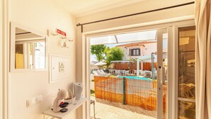 A room with a view of an outdoor swimming pool, a balcony, and a door leading outside. - Studio with Pool View Terrace (Alcácer do Sal)