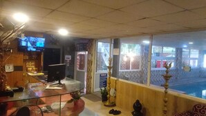 Un'area reception con una scrivania in vetro, una televisione, una sveglia e vista sull'esterno.