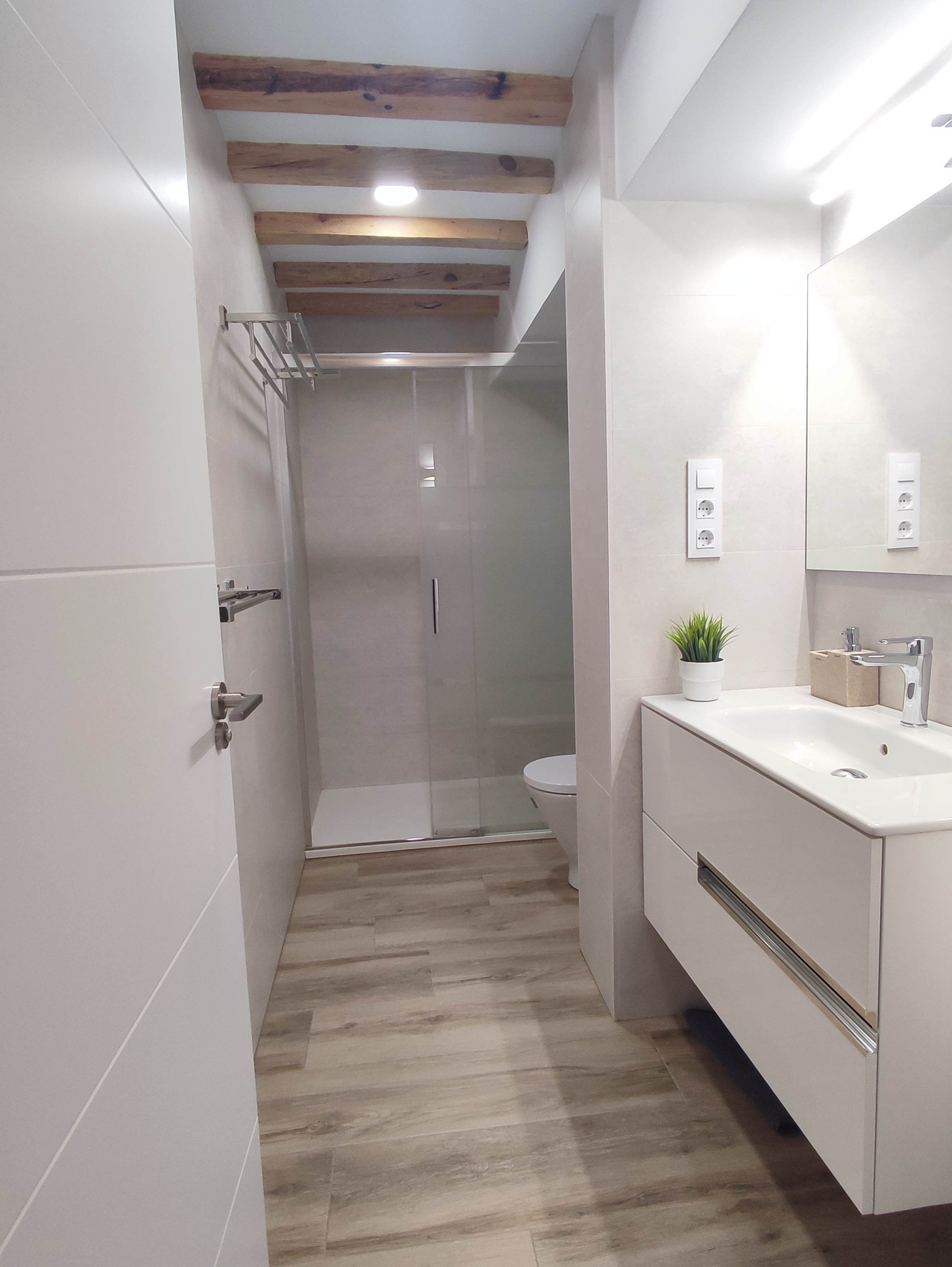 Une salle de bain moderne équipée d’une douche, de toilettes et d’un lavabo.