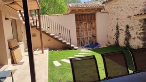 A patio area with a wooden staircase leading to a door, a small lawn, and outdoor furniture. - Cottage next to a river in a quiet village, ideal for families. (Castroserna de Arriba)