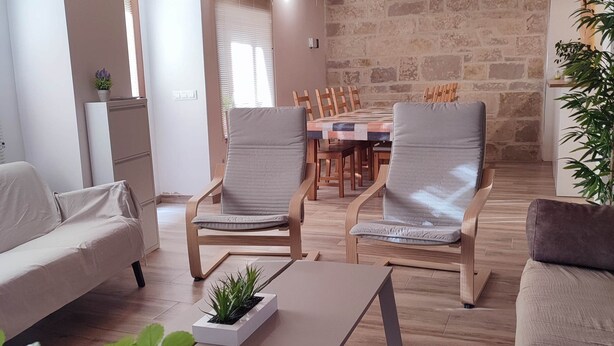 A cozy living room with a wooden ceiling, a dining table with chairs, and a sofa. - Cottage next to a river in a quiet village, ideal for families. (Castroserna de Arriba)
