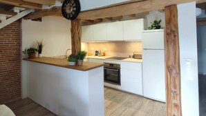 A modern kitchen with white cabinets, a wooden ceiling, and a built-in oven. - Cottage next to a river in a quiet village, ideal for families. (Castroserna de Arriba)
