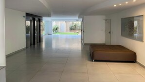 Un corridoio d'albergo spazioso con un grande letto, un'opera d'arte incorniciata e vista sull'area esterna.