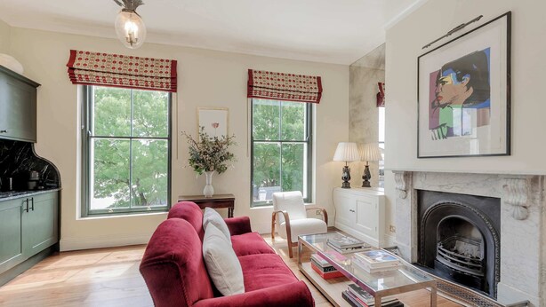 A living room with a red sofa, a fireplace, and large windows with red valances. - Stylish 1 Bedroom Apartment - Notting Hill (London)