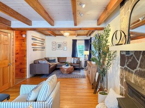 Ein gemütliches Wohnzimmer mit Kamin, Holzbalken und einer Steinwand.