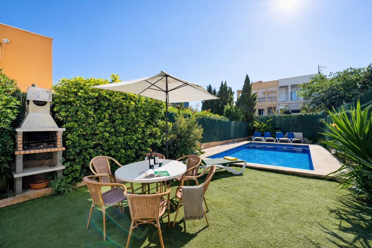 Ein Garten mit Grill, Pool und Gartenmöbeln.