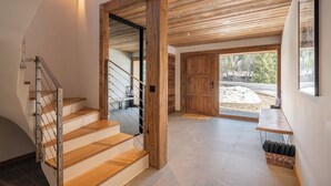 Gradi amb fustes i barana metàl·lica, que condueixen a un espai amb porta de fusta i vista cap a l'exterior.