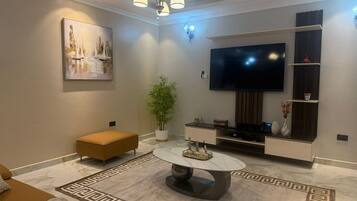 Apartment, 1 Bedroom | Living area | 65-inch Smart TV with digital channels, DVD player, pay films